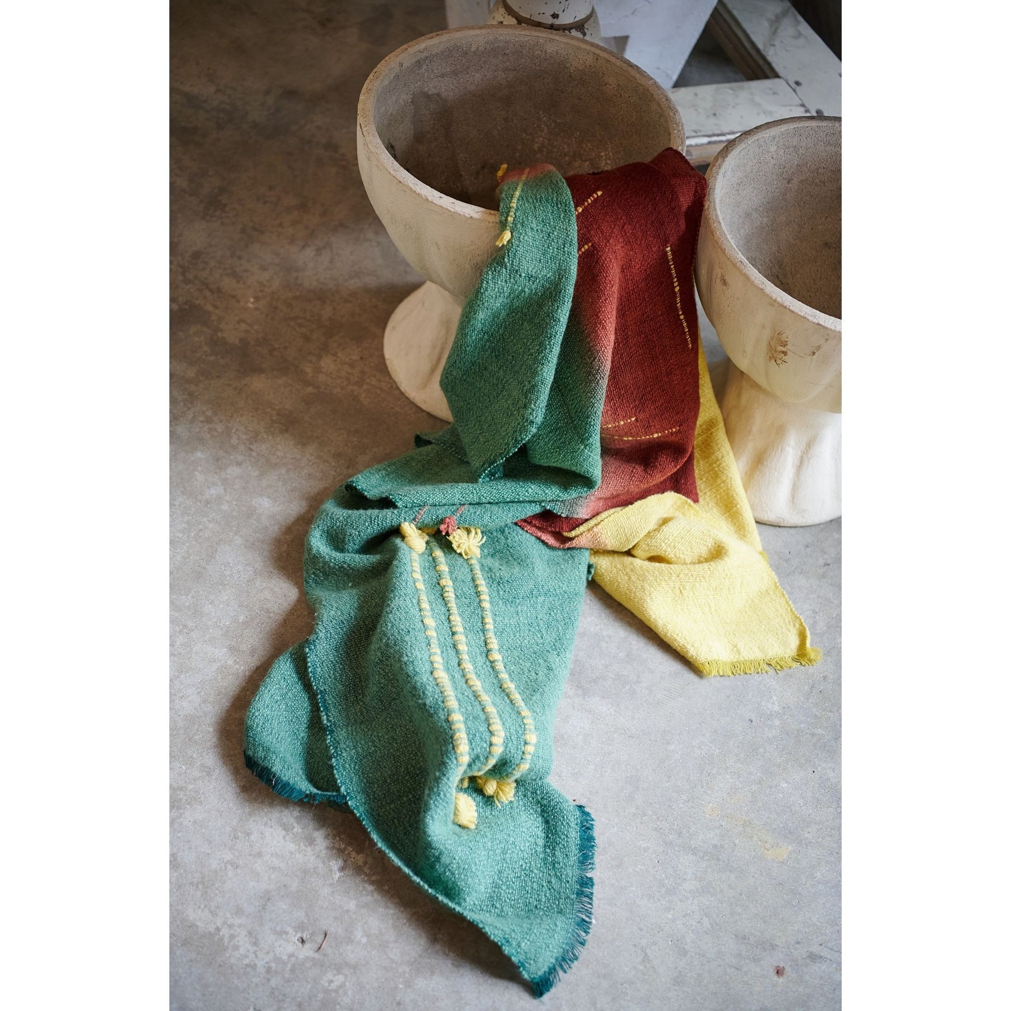 Avocado Green Multi Color Warm Hues Hand Woven Hand Knotted Textured Merino Throw draped over pots.
