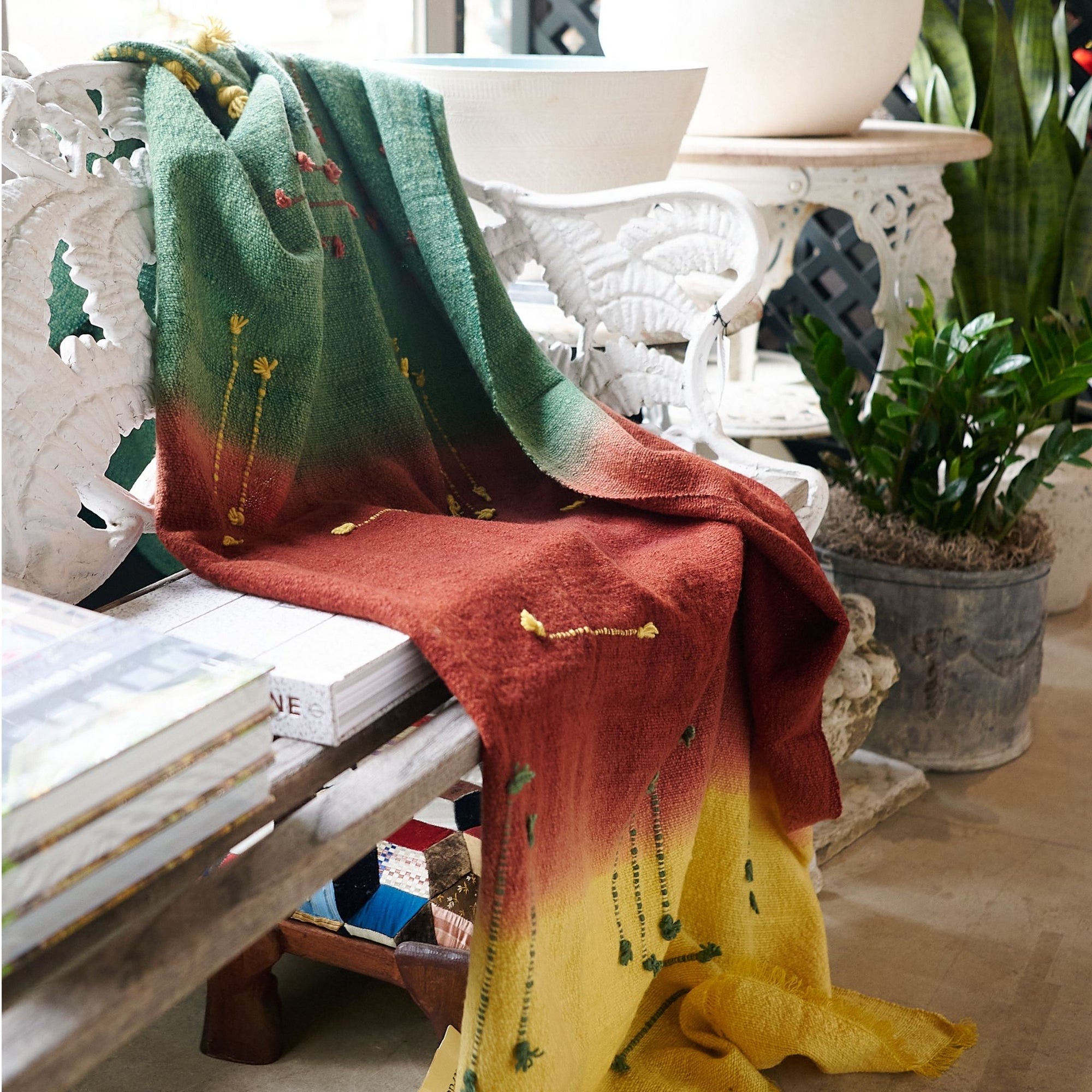 Avocado Green Multi Color Warm Hues Hand Woven Hand Knotted Textured Merino Throw draped over a chair in a cozy setting.