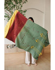 Avocado Green Multi Color Warm Hues Hand Woven Hand Knotted Textured Merino Throw displayed by a model indoors.