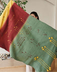 Avocado Green Multi Color Warm Hues Hand Woven Hand Knotted Textured Merino Throw draped elegantly by a person.