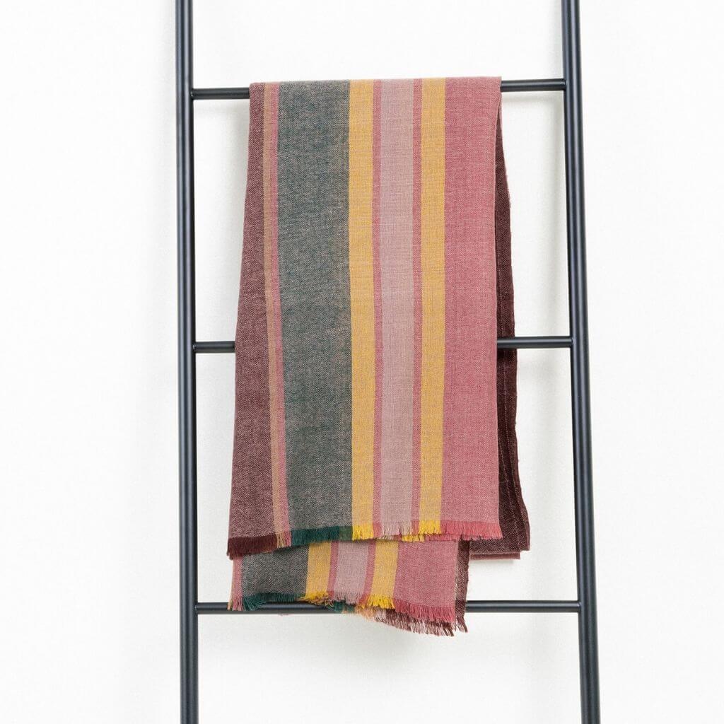 Barque Clay Modern Artisan Striped Soft Merino Handwoven Scarf hanging on a ladder display.