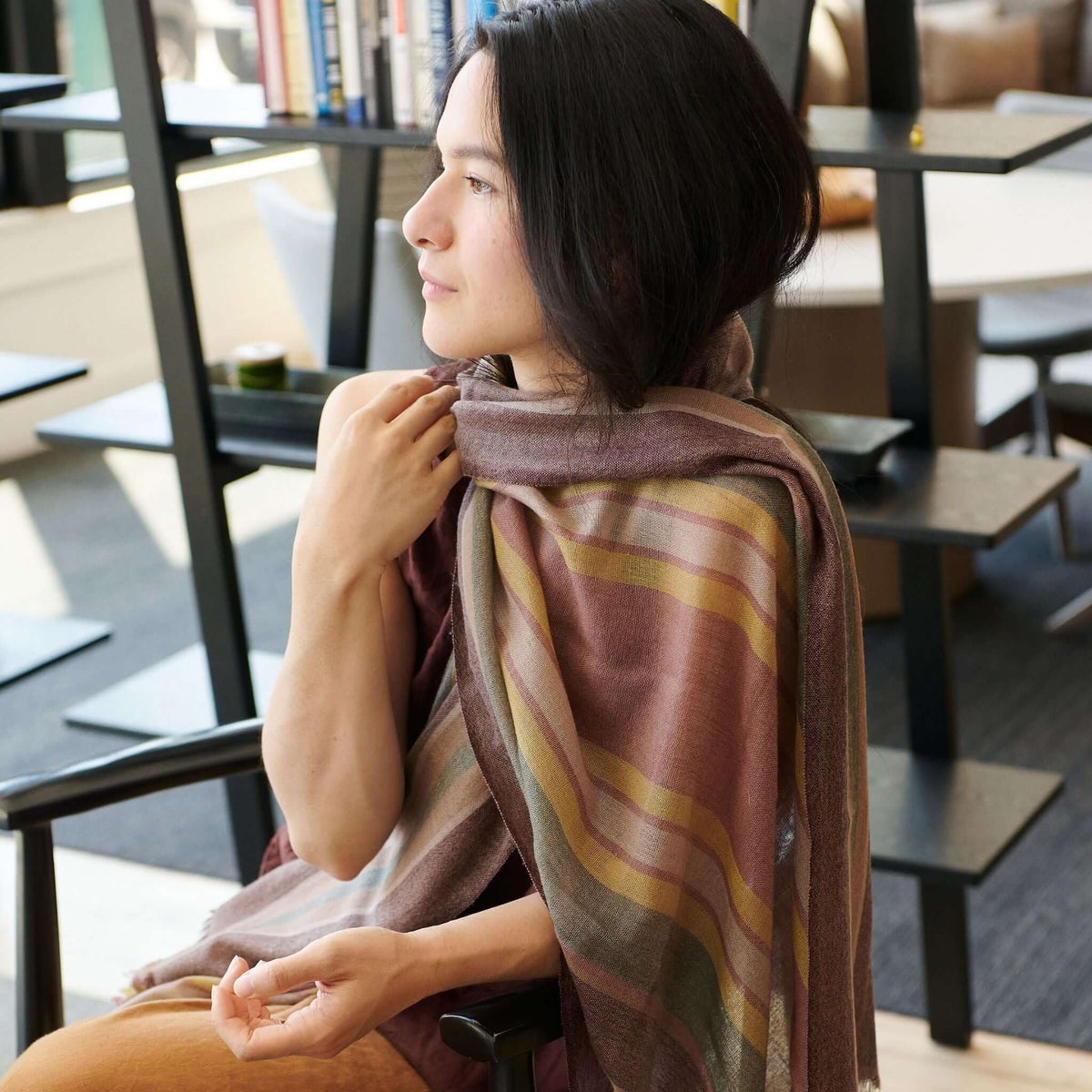 Woman wearing the Barque Clay Modern Artisan Striped Soft Merino Handwoven Scarf in a stylish setting.