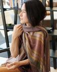 Woman wearing the Barque Clay Modern Artisan Striped Soft Merino Handwoven Scarf in a stylish setting.