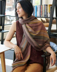 Woman wearing Barque Clay Modern Artisan Striped Soft Merino Handwoven Scarf in a stylish indoor setting.