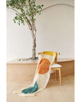 Cirq Moon Off White Multi Color Circle Pattern Hand Embroidered  Linen Silk Handloom Scarf draped on a chair with a tree backdrop.