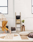 Dyoon Abstract Pattern Handwoven Artisanal Wool Rug displayed in a stylish living space with natural light.