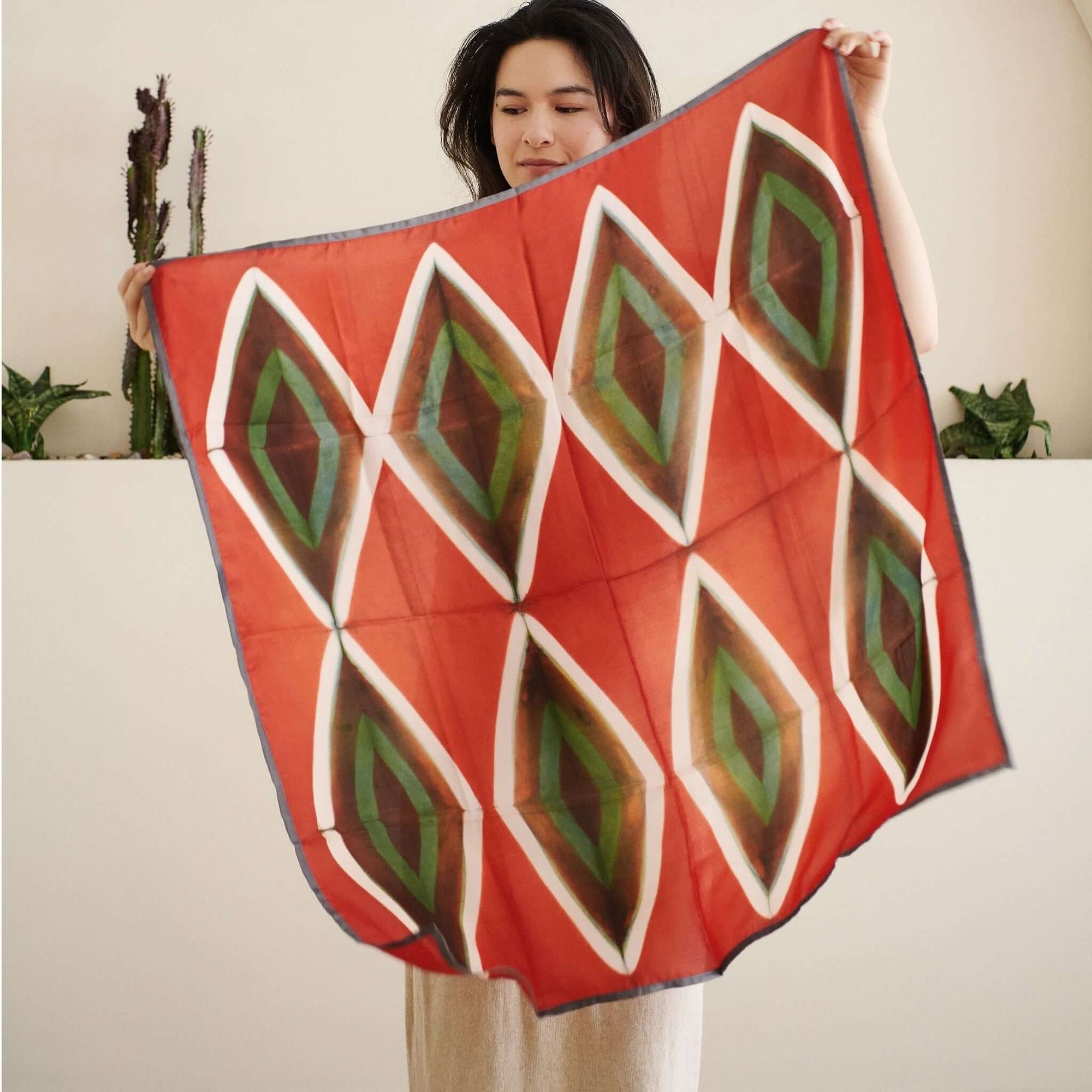 Fawn Square Silk Artisanal Scarf In Multicolor Hand Crafted Shibori Print displayed by a woman in a bright setting.