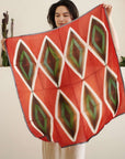 Fawn Square Silk Artisanal Scarf In Multicolor Hand Crafted Shibori Print displayed by a woman in a bright setting.