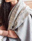 Flo Gray Textured Handloom Merino Throw elegantly draped over a person, showcasing its luxurious craftsmanship.