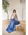 Hand Knotted Merino Textured Mari Throw Blanket in Blue Gray displayed by a woman in a modern interior.