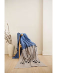 Hand Knotted Merino Textured Mari Throw Blanket in Blue Gray draped elegantly over a chair, highlighting its unique textures.
