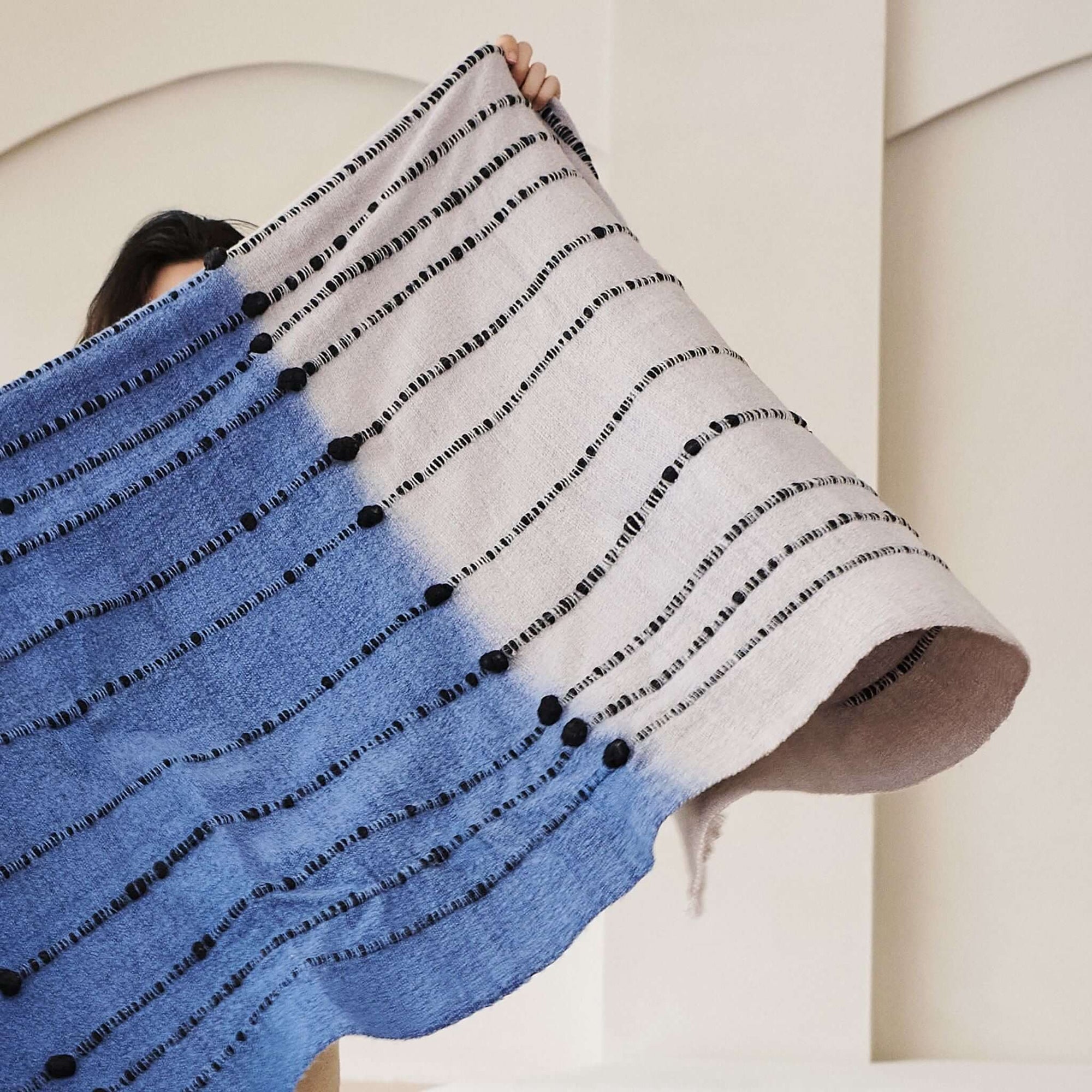 Hand Knotted Merino Textured Mari Throw Blanket in Blue Gray displayed, showcasing its serene color and unique texture.