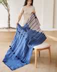Hand Knotted Merino Textured Mari Throw Blanket in Blue Gray displayed by a model in a cozy interior setting.