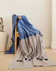 Hand Knotted Merino Textured Mari Throw Blanket in Blue Gray draped over a chair with a minimalist decor backdrop.