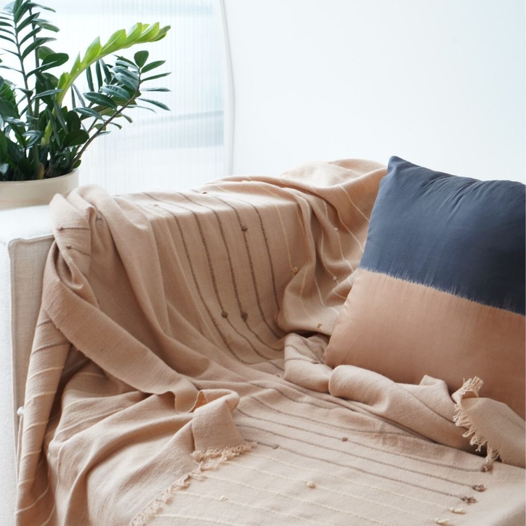Kala Black &amp; Gold Color Block Mulberry Silk Square Pillow on a cozy couch with a beige throw.