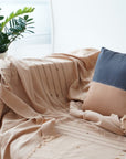 Kala Black & Gold Color Block Mulberry Silk Square Pillow on a cozy couch with a beige throw.
