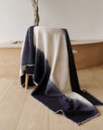 Ink Black White Ombre Textured Throw  In Hand Spun Merino And Hand Stitched Hem draped over a chair.