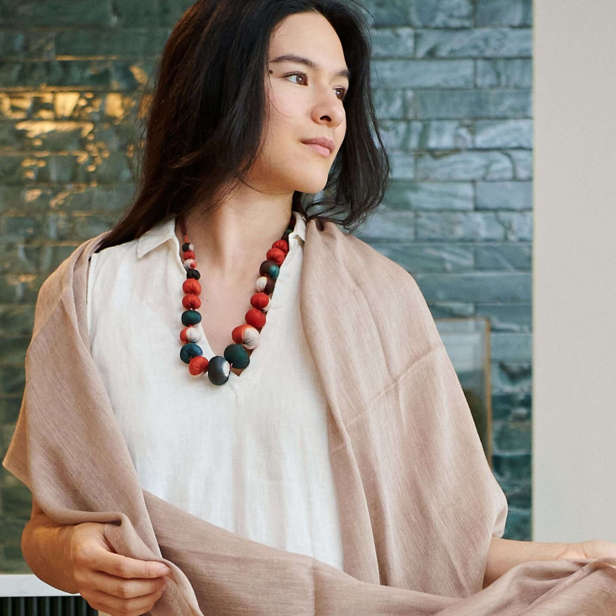 Jute Golden Brown Hand Woven Soft Linen Silk Scarf elegantly draped over a model with a colorful necklace.