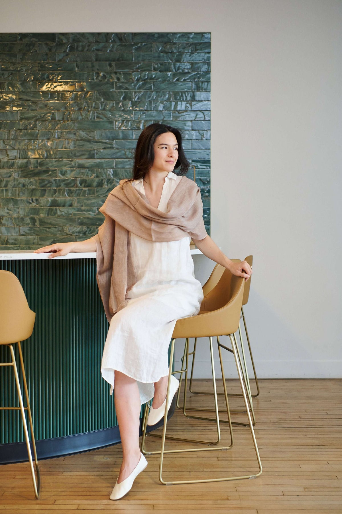 Jute Golden Brown Hand Woven Soft Linen Silk Scarf elegantly styled with a white dress in a modern setting.
