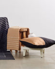 Kala Black & Gold Color Block Mulberry Silk Square Pillow on a wooden stool with textured blankets in a modern decor setting.