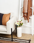 Kala Black & Gold Color Block Mulberry Silk Square Pillow on a stylish sofa with flowers and a cozy throw.