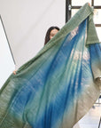A woman holding the Lake Moss Handwoven Merino Throw Blanket, showcasing serene blue-green shades.