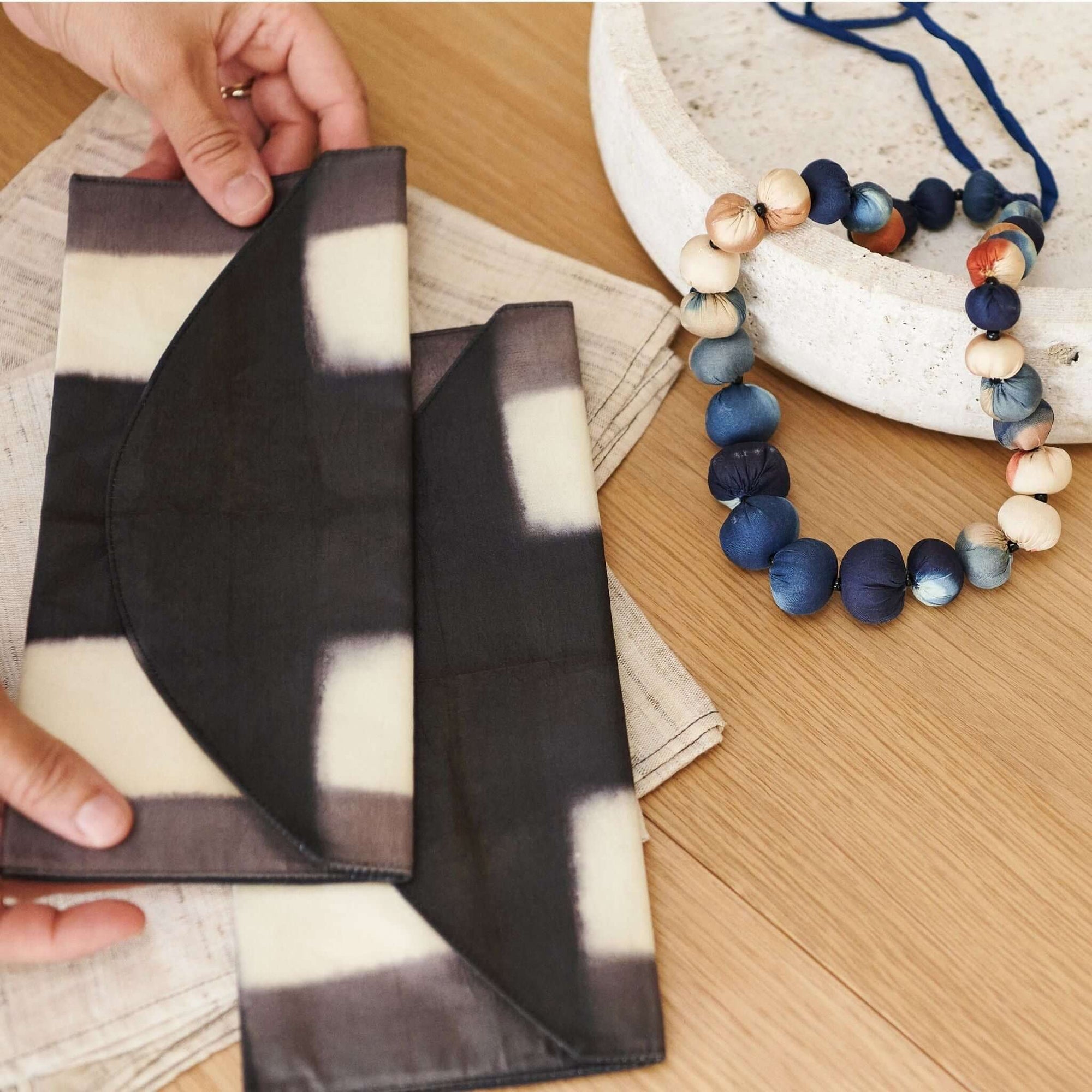 Melo Black Handcrafted Silk Travel Pouch Organizer with artisan details and a unique design on a wooden table.