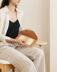 Melo Gold Mulberry Silk Shibori Hand Crafted Envelope Pouch held by a woman wearing casual clothing.