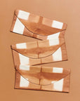 Melo Gold Mulberry Silk Shibori Hand Crafted Envelope Pouch showcasing three unique designs on a warm background.