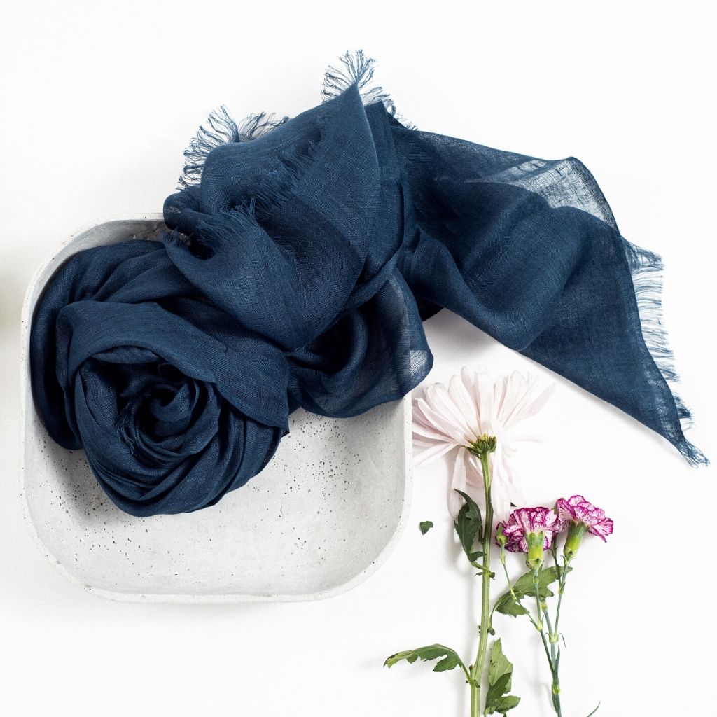 Midnight Navy Blue Hand Woven Linen Silk Blend Scarf elegantly displayed in a bowl with flowers.
