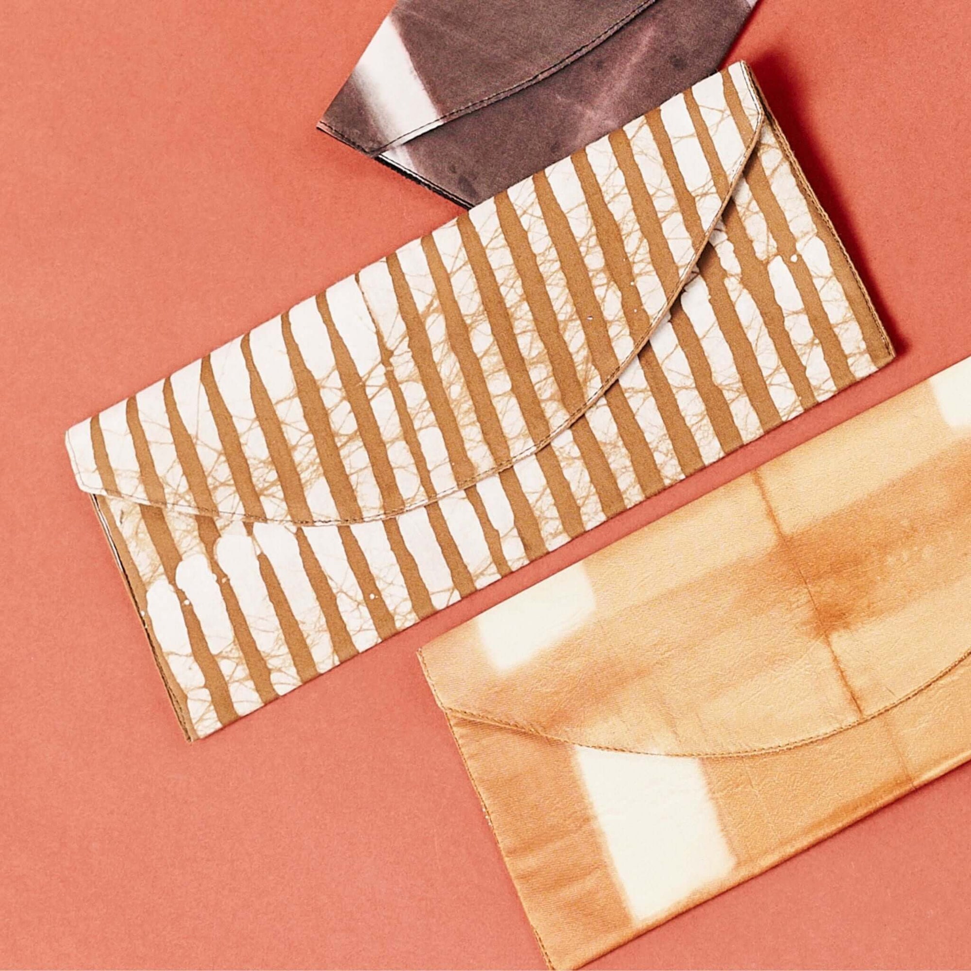 Oak Brown Stripes Cotton Wax Block Printed Envelope Pouch shown on a flat background with other pouches.