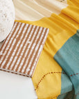 Oak Brown Zero Waste Handmade Artisanal Journal on a colorful fabric backdrop with a stone decoration.