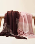Rosa Plush Maroon Plush Merino Queen Bedspread / Large Throw draped elegantly on a bench, showcasing its luxurious design.