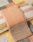 Shale Hand Woven Pastel Color Large Geometric Lumbar Pillow showcasing soft textures and pastel colors on a patterned rug.