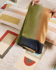 Shale Hand Woven Pastel Color Large Geometric Lumbar Pillow on a textured surface with colorful patterns.