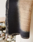 Siro Brown Handwoven Merino Artisan Throw Blanket showcasing intricate stitched detailing and a gradient design.