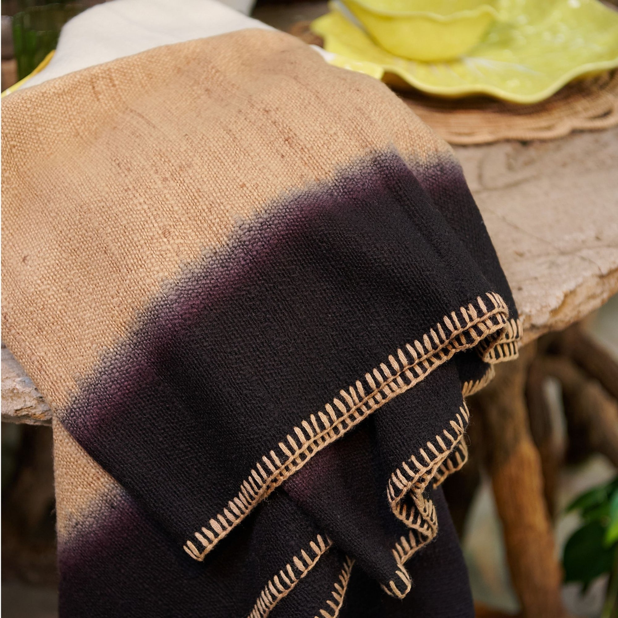 Siro Brown Handwoven Merino Artisan Throw Blanket draped elegantly on a table, showcasing its rich textures and stitching.