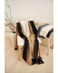 Siro Brown Handwoven Merino Artisan Throw Blanket draped over a wooden chair, showcasing soft textures and warm colors.