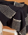 Walnut Black Yak With Hand Knotted Merino Stripes Handloom Throw displayed on a chair with patterned design.